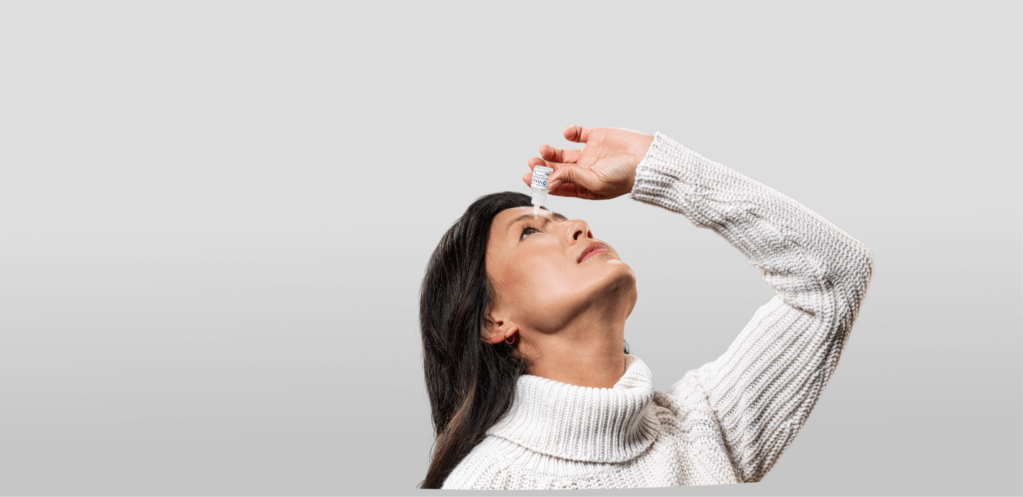 Woman putting VUITYTM prescription eyedrop in eye with VUITYTM bottle and packaging in foreground